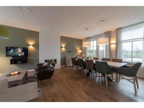科莱恩斯普拉特luxury 8 person Wellness villa with sauna的客厅配有桌椅和电视。