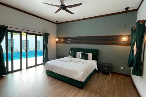 彭亨Villa Emerald: 3 Bedroom Pool Villa Near River的一间卧室配有一张带吊扇的床