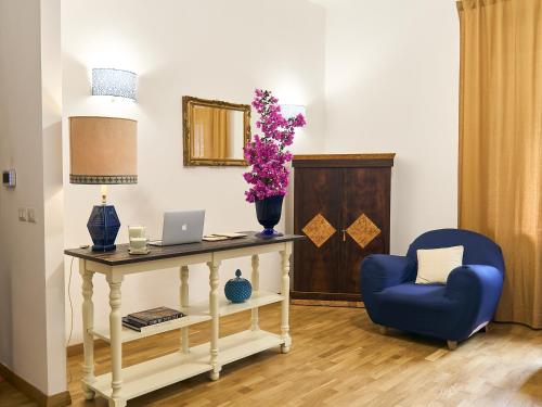 卡普多兰多Qurchiti的客房设有带笔记本电脑和蓝椅的桌子。