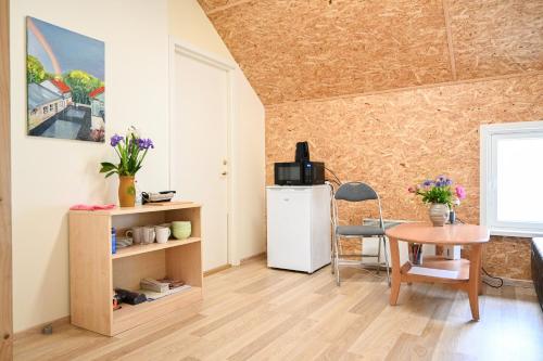 哈普萨卢Haapsalu Kunstikooli hostel的客厅配有小桌子和冰箱