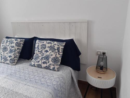 科蒂略Apartamentos Cotillo Family的一间卧室配有一张带蓝色和白色枕头的床