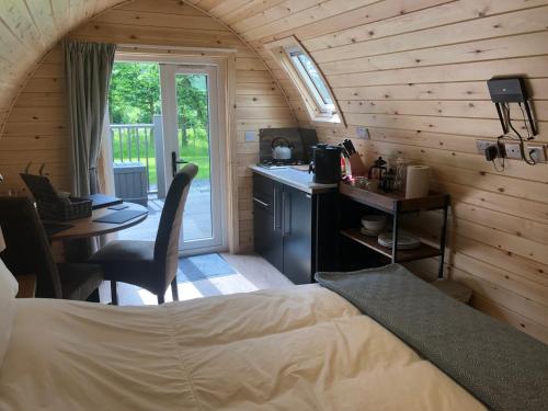 刘易斯Scallow Campsite的一间带一张床和一张书桌的卧室和一间厨房