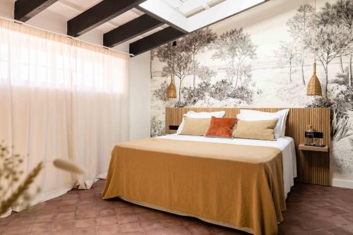 马翁El Consul Mao - Hotel Boutique的一间卧室配有一张带橙色枕头的大床
