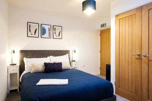 赛伦塞斯特Glevum Lodge - 2 Bedroom Town Centre Apartment的一间卧室配有蓝色的床和蓝色的毯子