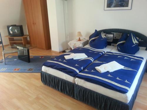 维斯马埃姆瓦瑟托膳食公寓酒店的一间卧室配有一张带蓝色床单和白色毛巾的床。
