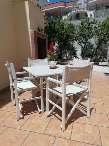 莫诺波利Solmar Casa Vacanze的庭院里的白色桌椅