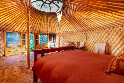 春溪Purling Brook Falls Gwongorella的蒙古包内一间卧室,配有一张床和一个时钟