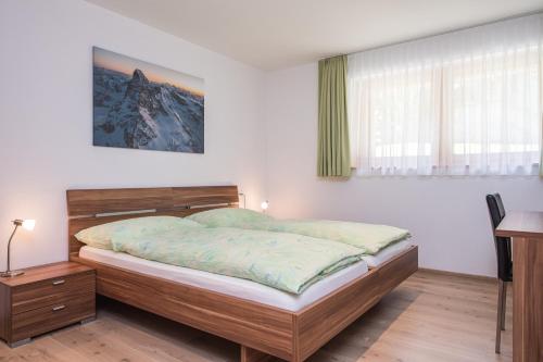 采尔马特Ferienhaus Casa Luna的一间卧室配有一张床、一张书桌和窗户。