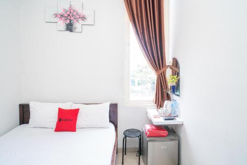 GununganjarRedDoorz Plus At Merr Rungkut Jl Gunung Anyar的卧室配有白色的床、红色枕头和窗户