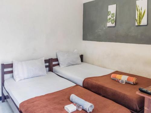 SukobumiKartini Guest House near Alun Alun Probolinggo的小型客房配有两张床,设有2张床。