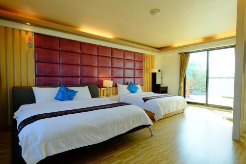 冬山乡优的休闲民宿 的酒店客房设有两张床和大窗户。