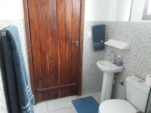 戈亚斯州上帕莱索A Taberna - chalés的浴室设有木门、卫生间和水槽。