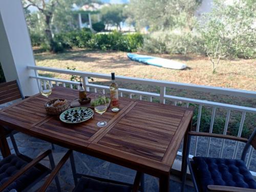 鲁巴达My Mediterranean Villa with Huge Garden and own Parking的阳台上的木桌,配有桌椅