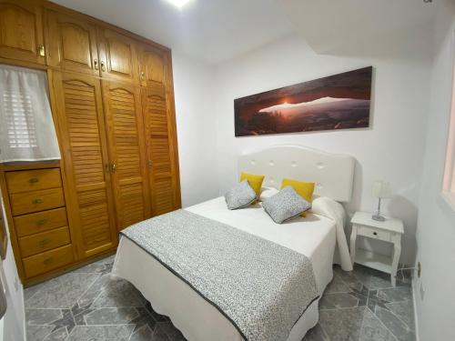 卡亚俄萨尔瓦赫Luar del Carmen的一间卧室配有白色床和黄色枕头