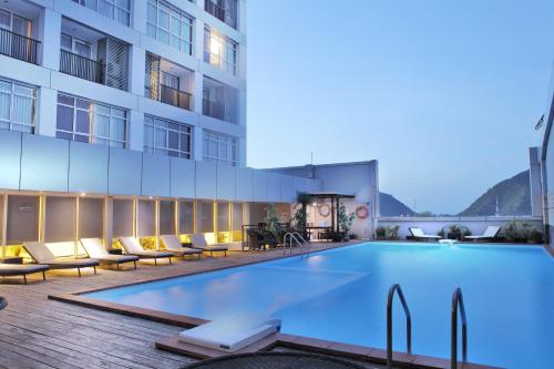 哥伦打洛省FOX Hotel Gorontalo的大楼旁的大型游泳池