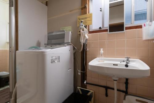 冈山Unique joy House的一间带水槽和冰箱的小浴室
