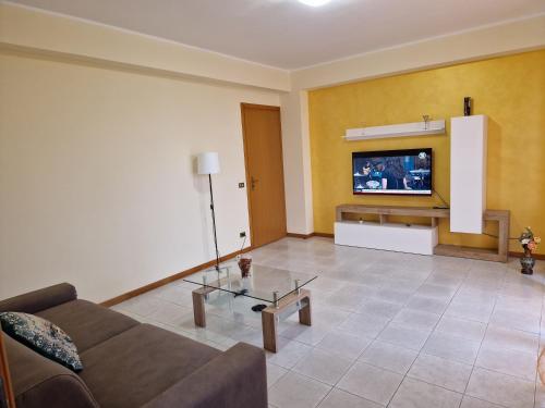 阿茨特雷扎L'Isola e i Faraglioni house的客厅配有沙发和墙上的电视