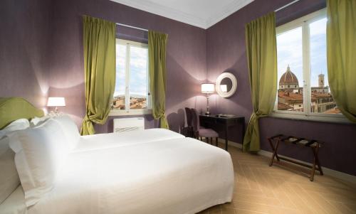佛罗伦萨圣朱利亚诺旅馆的卧室设有白色大床和窗户。