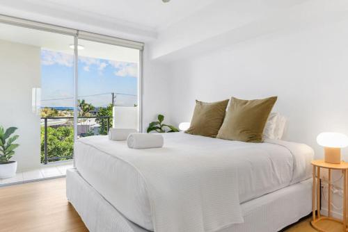 马库拉Fresh Beautifully Styled 2 BR Resort Apt at Marcoola的白色的卧室设有一张白色大床和一个窗户。