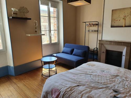 Mareuil-sur-AyLa Cour des Marotiers的一间卧室配有一张床和一张蓝色椅子