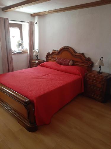 努斯Casa Elena的一间卧室配有红色的床罩和红色的床罩