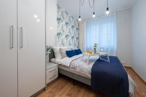 卡托维兹Apartment BlueBird Katowice near Spodek MCK & City Center的一间卧室配有蓝色和白色的墙壁。