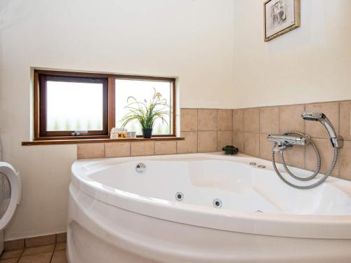 托斯明德8 person holiday home in Ulfborg的带窗户的浴室内的白色大浴缸