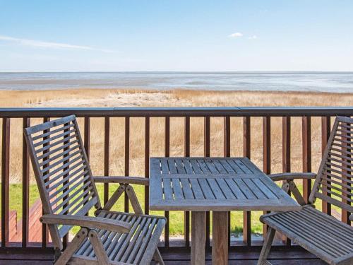 博利尔马克8 person holiday home in R m的海滩阳台配有两把椅子和一张桌子