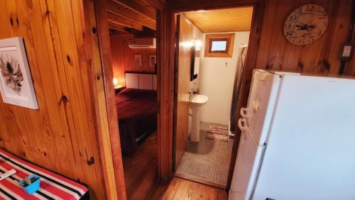 科隆Cabañas Pulmahue的一间小型客房,配有冰箱和一间卧室