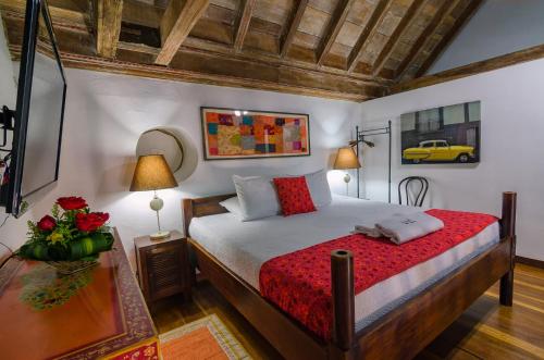 卡塔赫纳Casa Cordoba Román的一间卧室配有一张床和一张鲜花桌