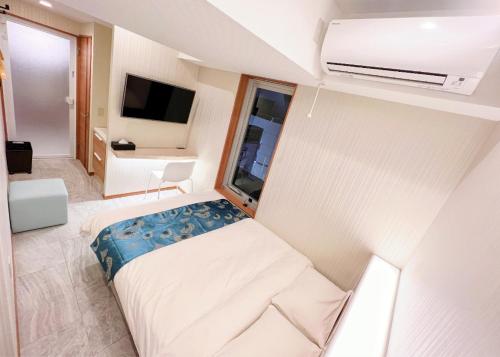 埼玉市Hotel mond omiya的小房间设有床和电视