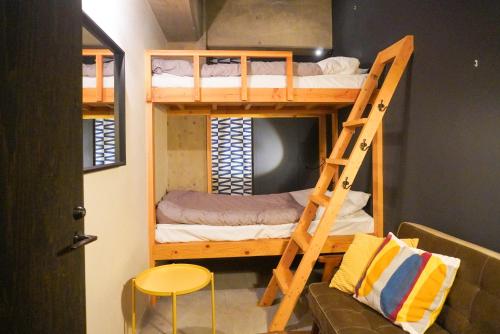 京都新闻间旅馆的客房设有带梯子和沙发的双层床。
