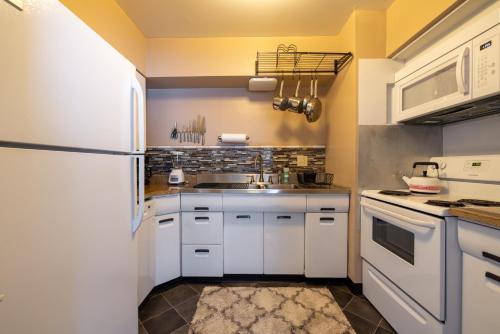 费尔维尤帕克Georgetown Villas 2-1b Ideal for long stays!的厨房配有白色橱柜和白色冰箱。