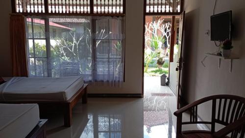 金塔马尼Hotel Segara的一间卧室设有一张床和一个滑动玻璃门