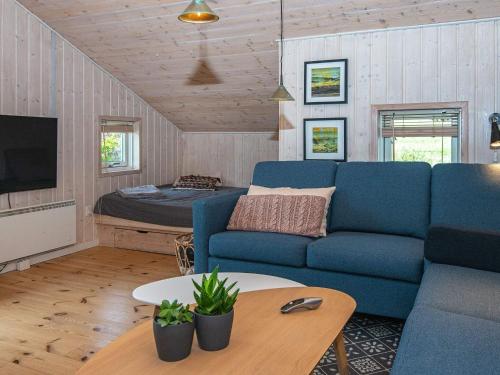 锡尔克堡Holiday home Silkeborg XIX的客厅配有蓝色的沙发和床。