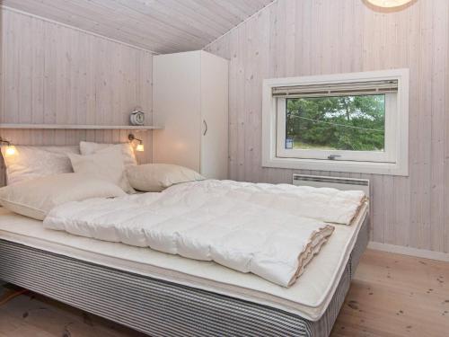 凡岛Holiday home Fanø CCVI的窗户客房内的一张大白色床