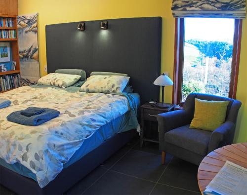 杰拉尔丁Kotare BandB的卧室配有床、椅子和窗户。