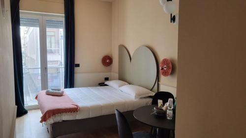 佩斯卡拉TUTTOTONDO的一间卧室配有一张床、一张桌子和一个窗户。