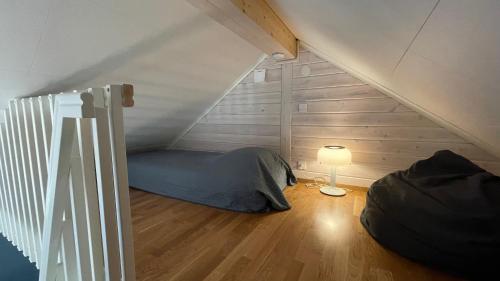 FlodaFloda, Minihus på 62m2 för plats för 4 vuxna och 2 barn的阁楼间设有床和灯