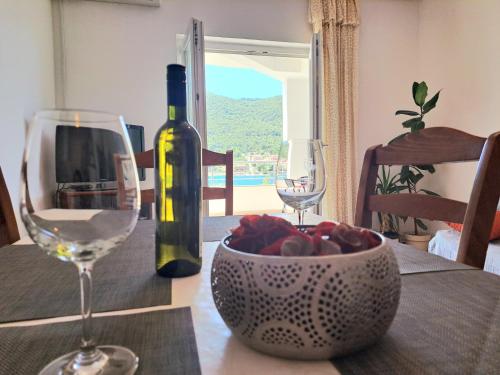 格雷巴蒂卡Open Sea Apartmani的一张桌子,上面放着一瓶葡萄酒和一碗水果
