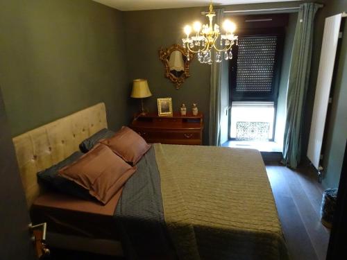 法勒斯堡BOIS DE CHENES HOUSE的一间卧室配有一张带吊灯和窗户的床。