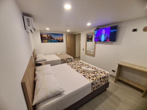 麦德林Hotel Suramericana的小房间设有两张床和电视
