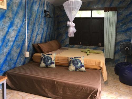 涛岛波塞冬度假村的一间卧室配有一张蓝色墙壁的床