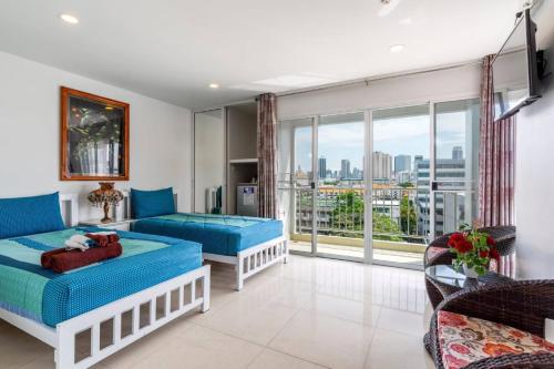 曼谷沙吞帕维纳酒店的客厅设有两张床和大窗户