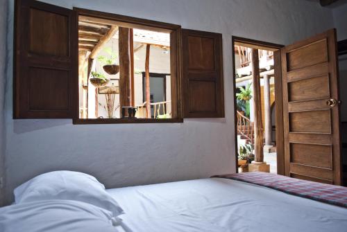 巴里查拉阿帕里西奥洛佩兹旅馆的一间卧室设有一张床和一个开放式窗户。