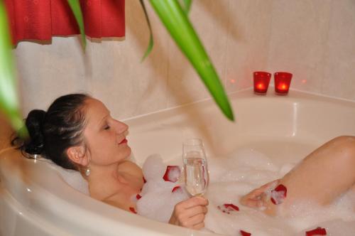 施特罗布尔格里尔公寓酒店的坐在浴缸里的女人,喝一杯香槟
