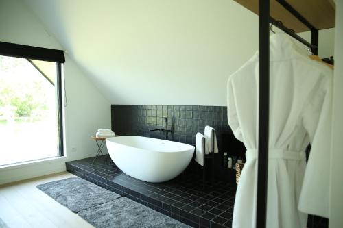 AartrijkeRozeboom Loft的浴室设有大浴缸和黑色瓷砖。
