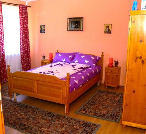 乔阿久拜Apartament Iulia的一间卧室配有一张紫色床单的床