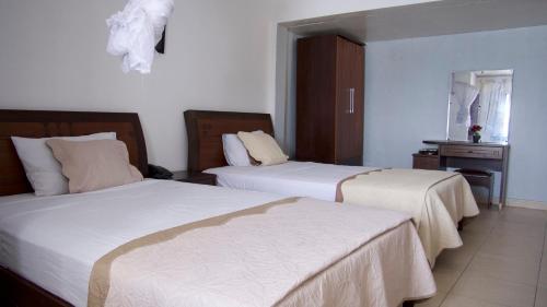 MutsamuduOcéanis Hotel的酒店客房,设有两张床和镜子