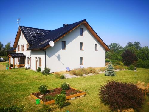 米泽德沃兹Pensjonat Ślepowron的屋顶上设有太阳能电池板的白色房子